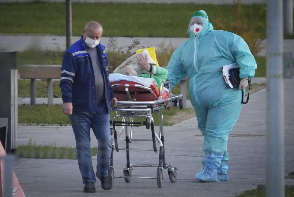 Medical workers carry a patient suspected of having coronavirus on a stretcher at a hospital in Kommunarka, outside Moscow, Russia, Monday, Oct. 11, 2021. Russia's daily coronavirus infections and deaths are hovering near all-time highs amid a laggard vaccination rate and the Kremlin's reluctance to toughen restrictions. Russia's state coronavirus task force reported 29,409 new confirmed cases Monday. That's the highest number since the start of the year and just slightly lower than the pandemic record reached in December. (AP Photo/Alexander Zemlianichenko)