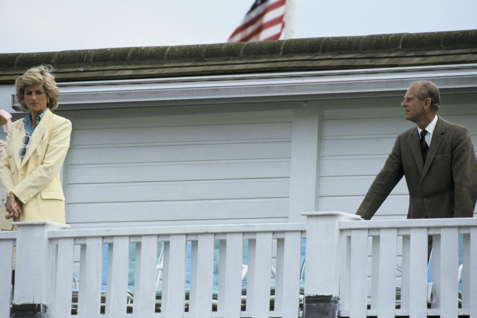 Prince Philip and Princess Diana stand on a balcony together