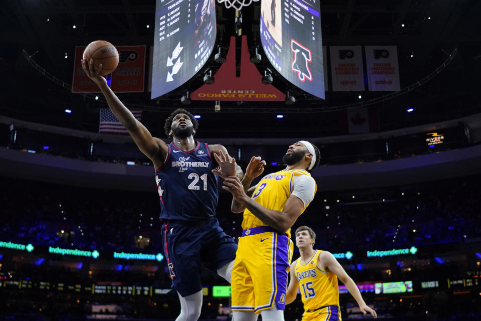 Joel Embiid, izquierda, de los 76ers de Filadelfia, se alza para encestar un tiro ante la mirada de Anthony Davis, de los Lakers de Los Ángeles, durante la primera mitad del juego de baloncesto de la NBA, el lunes 27 de noviembre de 2023, en Filadelfia. (AP Foto/Matt Slocum)