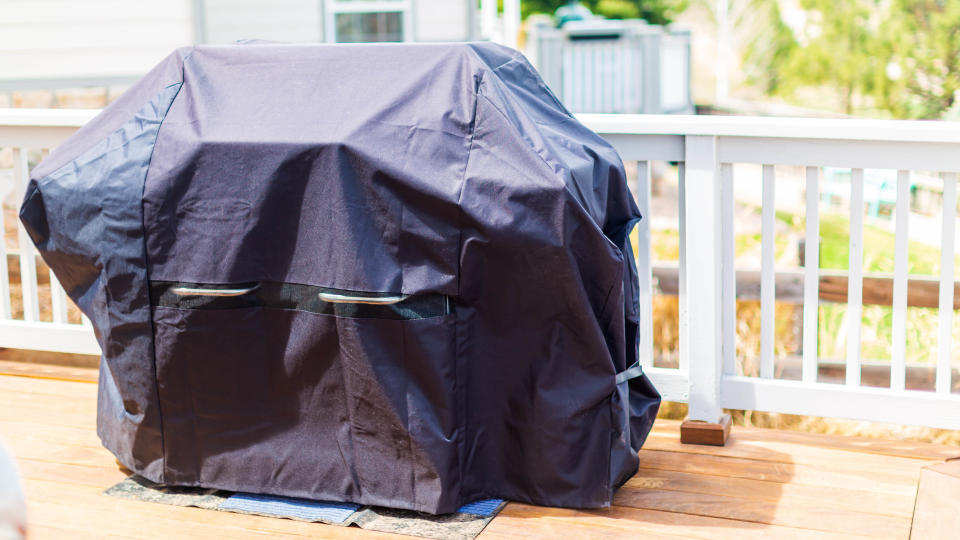 A grill stored under a cover