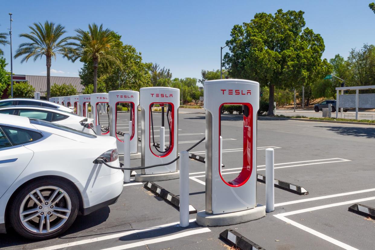 White Teslas charging at Tesla Supercharger Station at the Brea Mall, Brea, California, on a sunny day