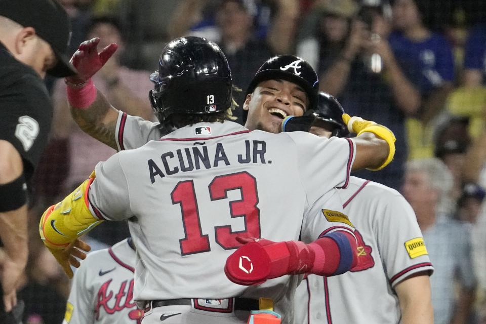 Atlanta Braves' Ronald Acuna Jr., left, celebrates with Orlando Arcia after hitting a grand slam during the second inning of a baseball game against the Los Angeles Dodgers Thursday, Aug. 31, 2023, in Los Angeles. (AP Photo/Mark J. Terrill)