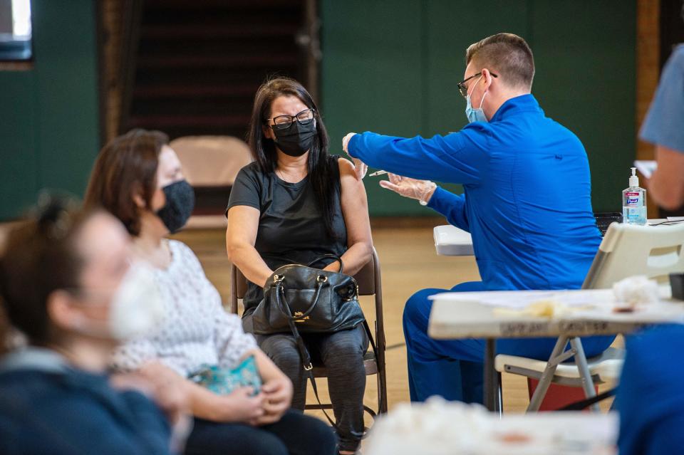 A woman squints as she receives her second dose of the Moderna Covid-19 vaccine at the mobile Covid-19 vaccination clinic,run by Hartford Healthcare at Saint Charles Borromeo Catholic Church's McGivney community center in Bridgeport, Connecticut on April 20, 2021. (Joseph Prezioso/AFP via Getty Images)