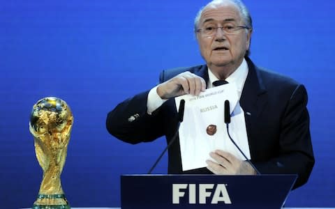 FIFA President Blatter holds up the name of Russia at the 2010 announcement - Credit: AFP