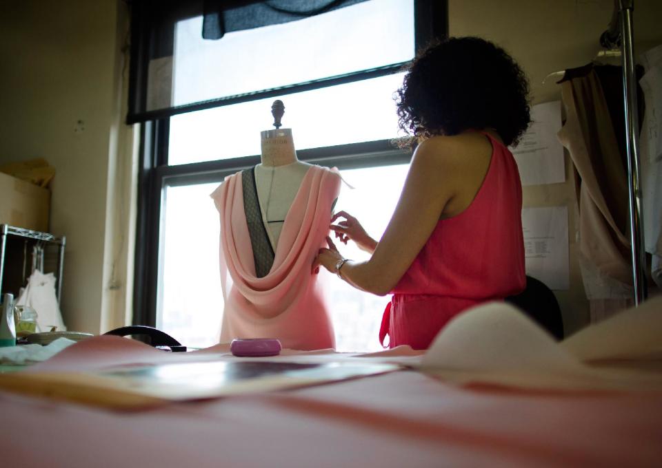 In this Aug 20, 2013 photo, pattern maker Luz Pyne pins cloth to a mannequin at the New York studio of fashion designer Carmen Marc Valvo. Valvo will show his Spring 2014 collection on Sept. 6 at Lincoln Center in New York. (AP Photo/John Minchillo)