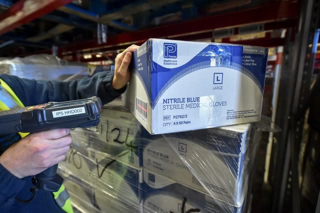 A warehouse worker scans medical gloves