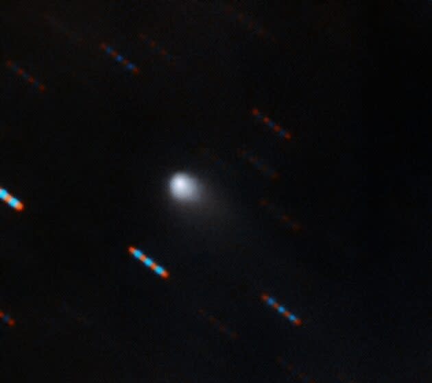 A two-color composite image from the Gemini North Multi-Object Spectrograph in Hawaii shows the interstellar object 2I/Borisov. Blue and red dashes are images of background stars that appear to streak due to the comet’s motion. (Gemini Observatory / NSF / AURA Image / Travis Rector)