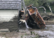 FILE - In this Jan. 9, 2018 file photo provided by Santa Barbara County Fire Department, a Santa Barbara County Fire Search dog, looks for victims in damaged and destroyed homes in Montecito, Calif. following deadly runoff of mud and debris from heavy rain. A Southern California utility has agreed to pay $360 million to settle lawsuits brought by cities, counties and other public agencies over deadly wildfires sparked by its equipment in the last two years, including one that was later blamed for a mudslide that killed more than 20 people. An attorney for 23 public entities said Wednesday, Nov. 13, 2019, that Southern California Edison has agreed to the sum to repay taxpayers for firefighting and damage from the Thomas Fire in 2017 and Woolsey Fire last year. (Mike Eliason/Santa Barbara County Fire Department via AP,File)