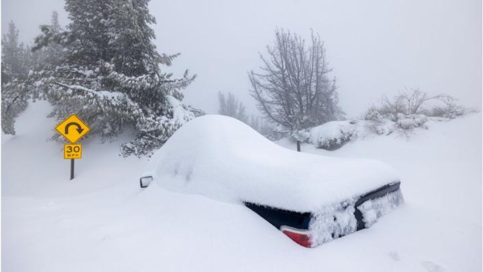Un vehículo enterrado bajo la nieve es abandonado a lo largo de una carretera