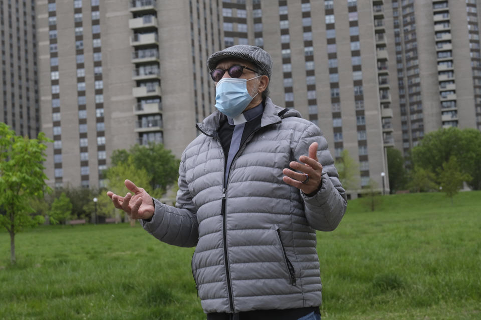 Bishop Angelo Rosario talks to reporters near his home in Co-op City in the Bronx borough of New York, Wednesday, May 6, 2020. Within the Bronx, almost no place has been hit as hard as Co-op City. Data released by city health officials Monday revealed that the virus has killed at least 155 people living in the zip code that covers the complex. That’s roughly 1 of every 282 residents. (AP Photo/Seth Wenig)