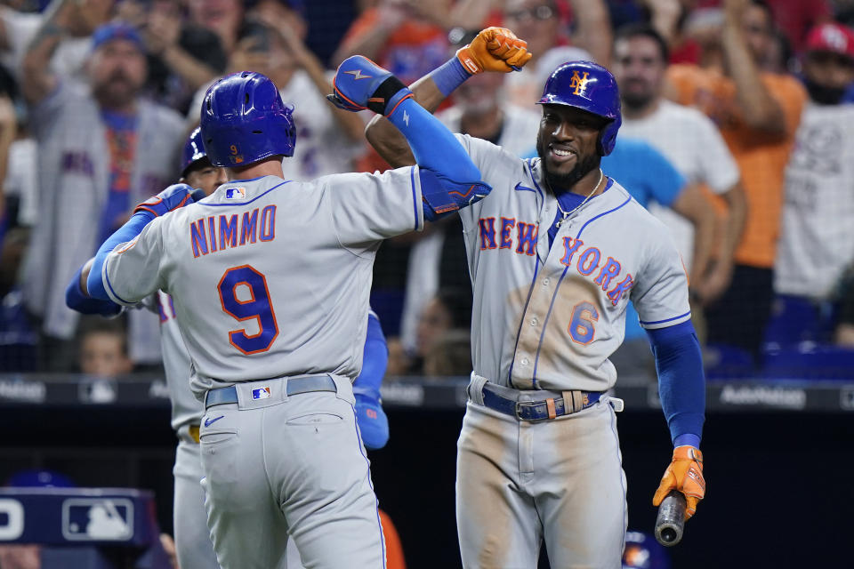 New York Mets' Brandon Nimmo (9) is congratulated by Starling Marte (6) after Nimmo hit a home run scoring Eduardo Escobar, during the eighth inning of a baseball game against the Miami Marlins, Friday, July 29, 2022, in Miami. (AP Photo/Wilfredo Lee)