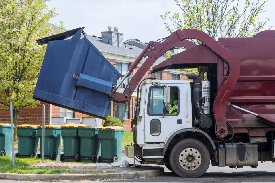 Mülllaster leert Müllcontainer. 