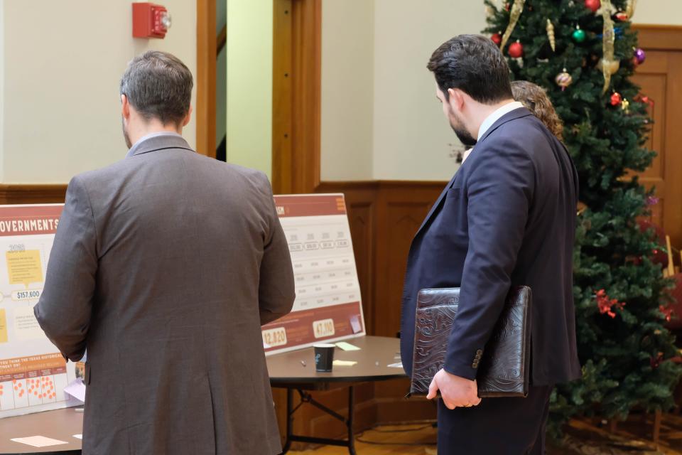 Guests at the Texas Historical Commission's preservation event look over the interactive displays at the Sante Fe Building Auditorium Thursday.