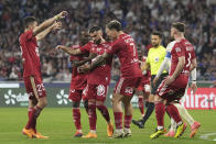 Brest's Romain Del Castillo, center, is congratulated after scoring his side's 2nd goal during a French League One soccer match between Lyon and Brest at the Groupama stadium, outside Lyon, France, Sunday, April 14, 2024. (AP Photo/Laurent Cipriani)