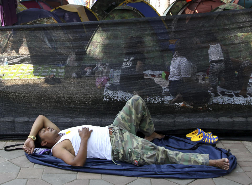 An anti-government protester takes a nap at an encampment inside Lumpini park in Bangkok, Thailand Tuesday, March 18, 2014. Thailand’s government is lifting a state of emergency in Bangkok and surrounding areas after violence related to the country’s political crisis eased. (AP Photo/Apichart Weerawong)