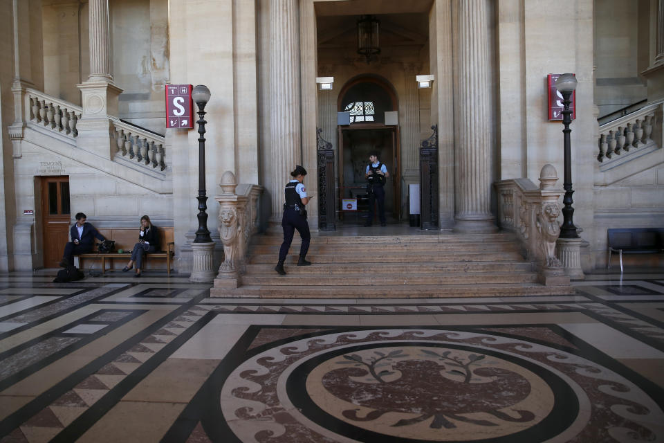 French police officer walks up the entrance of the court room as eight people are going on trial in relation to a bungled terrorist plot against Notre Dame Cathedral, in Paris, Monday, Sept. 23, 2019. The key suspects are two French women who pledged allegiance to the Islamic State group. They allegedly tried to explode a vehicle laden with fuel-doused gas canisters in the shadow of the medieval monument in 2016. (AP Photo/Francois Mori)