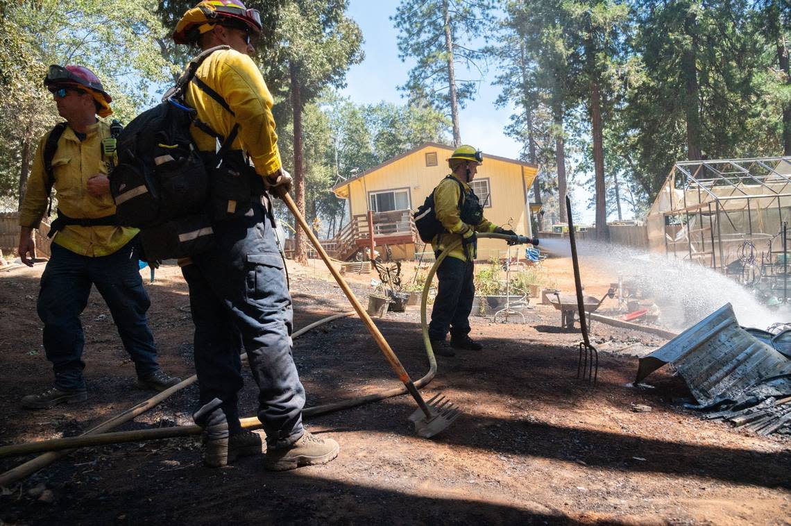 Firefighters with the Monterey Fire Department work to protect the property of a home in Cohasset from further fire damage on Friday, July 26, 2024. “We’re staying busy, which helps,” Capt. Robert Klemek, left, said. “The fact that we keep getting these saves is very motivational for us. It’s tough work, but you just do it.”