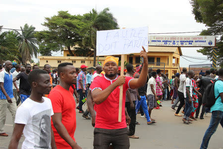 A man holds up a sign, which reads: "Faure must go", during an opposition protest calling for the immediate resignation of President Faure Gnassingbe in Lome, Togo, September 6, 2017. REUTERS/Noel Kokou Tadegnon