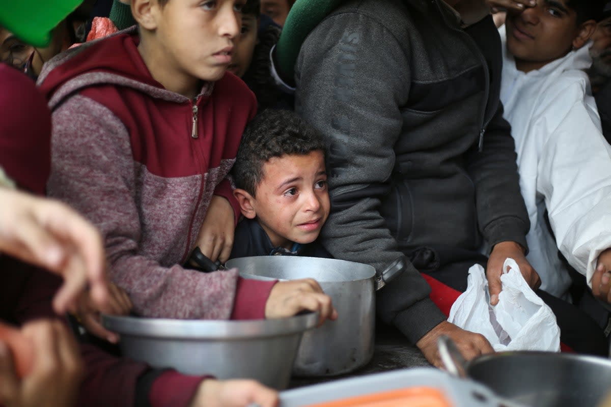 Palestinians line up for free food distribution during the ongoing Israeli air and ground offensive in Khan Younis, Gaza Strip, Friday, Feb. 2, 2024. (AP Photo/Hatem Ali)