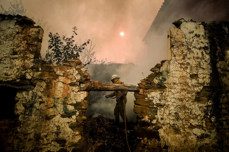 A National Guard Firefighter uses a hose during a wildfire on Roda village in Macao, central Portugal on July 21, 2019. (Photo: Patricia De Melo Moreira/AFP/Getty Images)