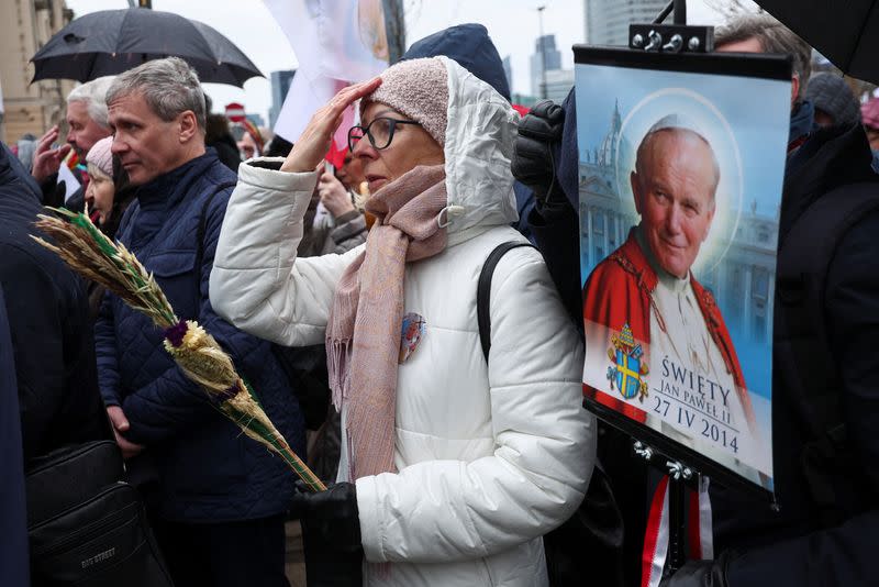 People march in defense of pope John Paul II on his death anniversary in Warsaw