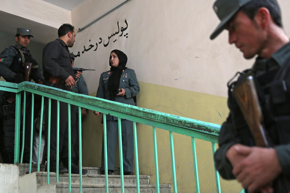 Afghanistan's first-ever female district police chief, Col. Jamila Bayaz, 50, center, talks to her secretary as she prepares for a walk around the center of the city to review check points in Kabul, Afghanistan, Thursday, Jan. 16, 2014. Afghanistan's first-ever female district police chief drew stares on Thursday as she drove and walked around the center of the city, reviewing check points and some of the important business and administrative facilities she is tasked with protecting. (AP Photo/Massoud Hossaini)