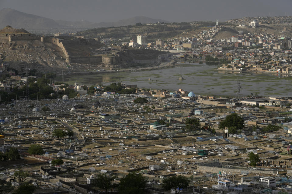 A view of a sprawling cemetery in Kabul, Afghanistan, Monday, May 9, 2022. (There are cemeteries all over Afghanistan's capital, Kabul, many of them filled with the dead from the country's decades of war. They are incorporated casually into Afghans' lives. They provide open spaces where children play football or cricket or fly kites, where adults hang out, smoking, talking and joking, since there are few public parks. AP Photo/Ebrahim Noroozi)
