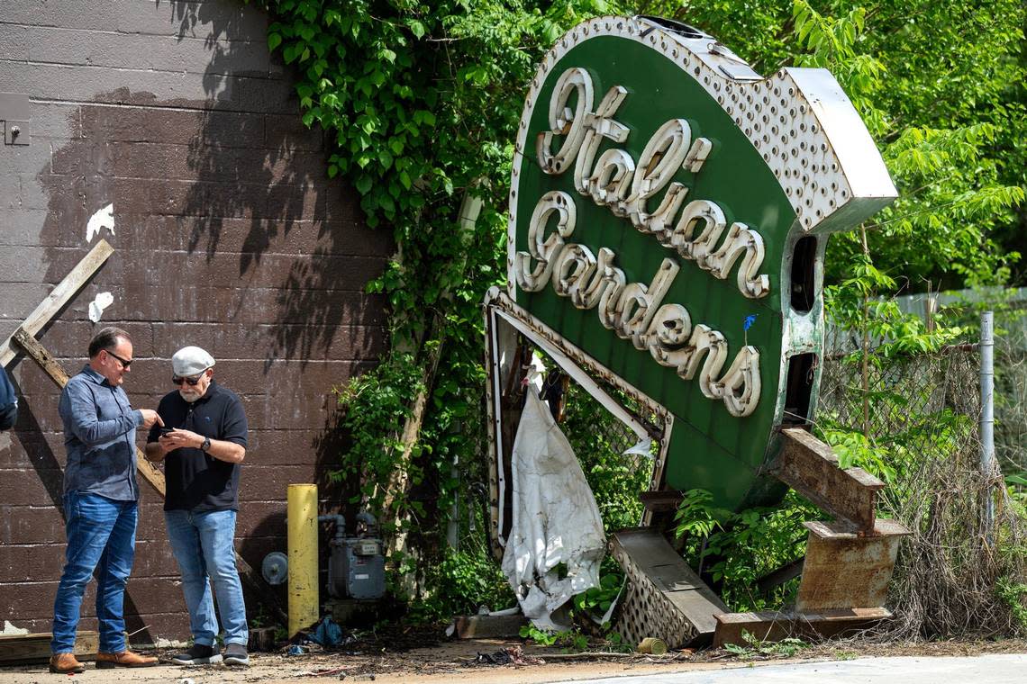 Brian McAllister, left, and Nick Vedros talk near the Italian Gardens neon sign purchased by the Lumi neon museum from Thomas Cobian of Downtown Neon Gallery & Art Studio.