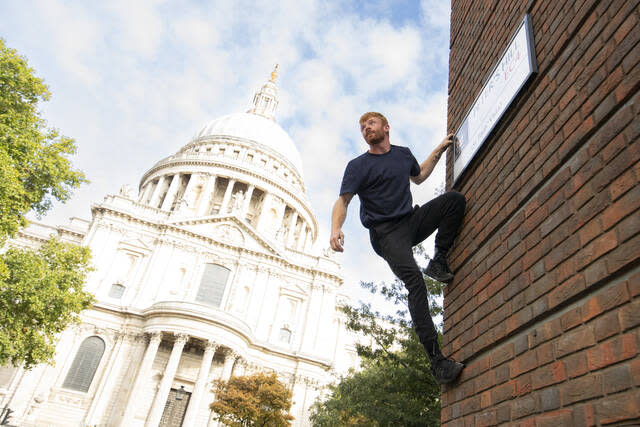 Free runner Toby Segar scales a wall in front of St Paul's Cathedral