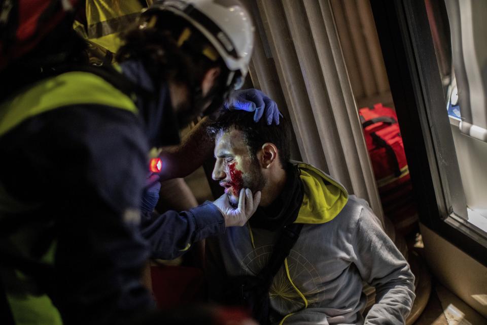 Paramedics attend a protestor during clashes with police in Barcelona, Spain, early Friday, Oct. 18, 2019. (Photo: Bernat Armangue/AP)