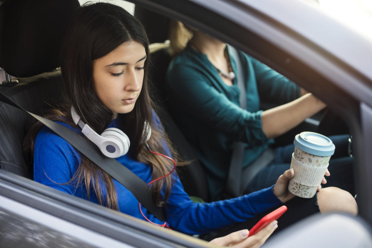 Teenage girl traveling in a car with her mother.