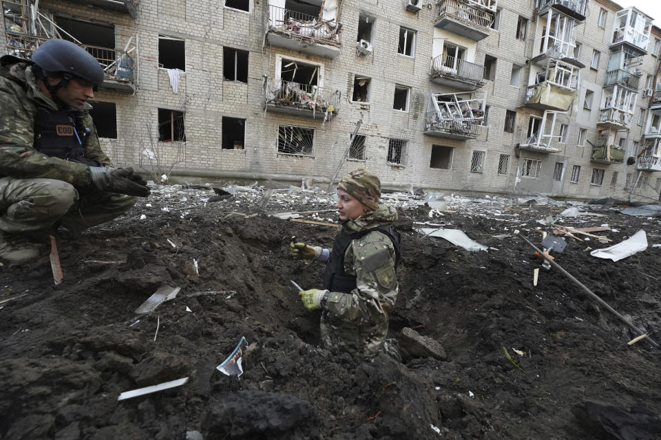 Policías inspeccionan un cráter frente a un edificio residencial dañado por un ataque ruso en Jarkív, Ucrania, el miércoles 27 de marzo de 2024. (AP Foto/Andrii Marienko)
