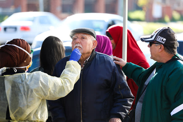 An elderly man has a Covid-19 test under the guidance of a member of the testing team during a COVID-19 testing blitz in the suburb of Broadmeadows in Melbourne.