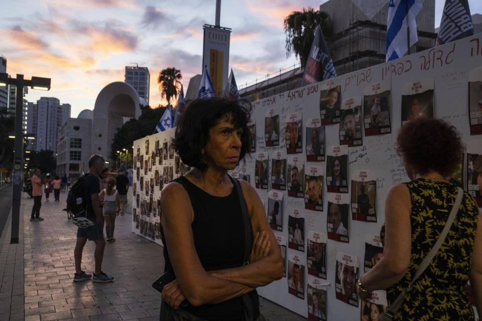 FILE - People look at photos of Israelis missing and held captive in Gaza, displayed on a wall in Tel Aviv, on Saturday Oct. 21, 2023. One of the missing, Ohad Munder-Zichri, turned 9 on Monday. But instead of celebrating at home with his family and friends, he was somewhere in Gaza, one of more than 200 Israelis held hostage by Hamas since their devastating Oct. 7 incursion. (AP Photo/Petros Giannakouris, File)