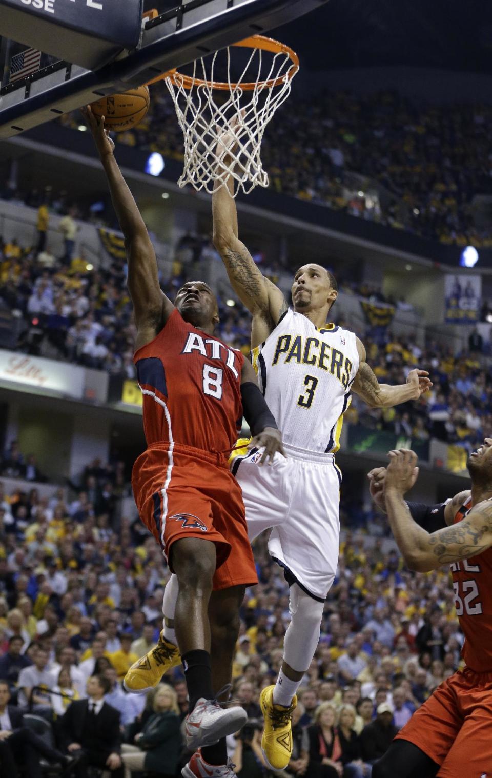 Atlanta Hawks' Shelvin Mack (8) puts up a shot against Indiana Pacers' George Hill (3) during the first half in Game 5 of an opening-round NBA basketball playoff series Monday, April 28, 2014, in Indianapolis. (AP Photo/Darron Cummings)