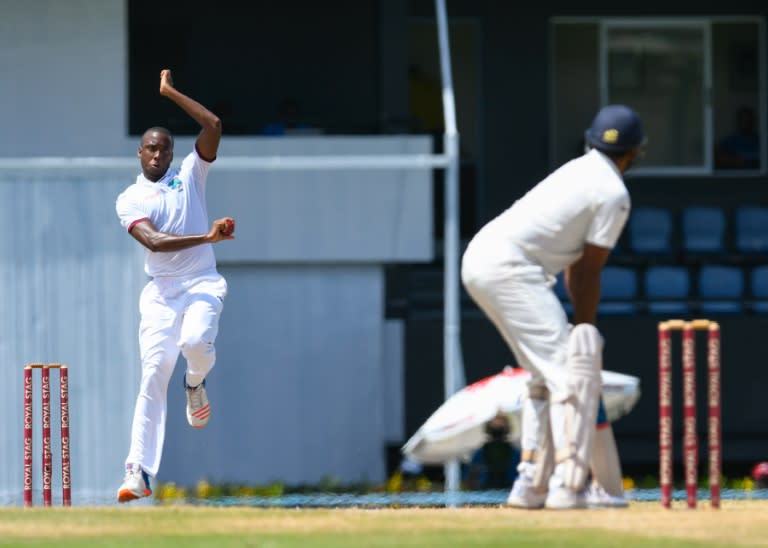 Miguel Cummins (L) of West Indies bowls against India to finish with 6 wickets for 48 runs on the final day of the third Test on August 13, 2016