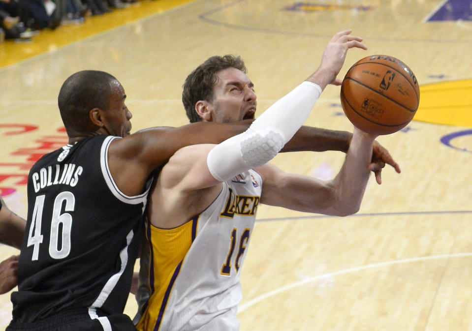Brooklyn Nets center Jason Collins, left, fouls Los Angeles Lakers center Pau Gasol during the second half of an NBA basketball game, Sunday, Feb. 23, 2014, in Los Angeles. The Nets won 108-102. (AP Photo/Mark J. Terrill)