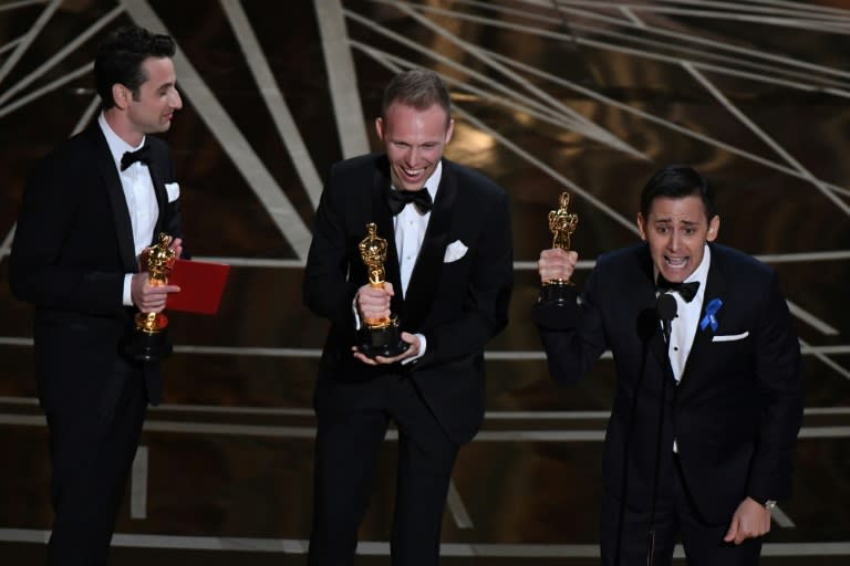 US composers Justin Hurwitz (L), Justin Paul (C) and Benj Pasek celebrate on stage after they won the best original song award for "City of Stars" from "La La Land" at the 89th Oscars on February 26, 2017