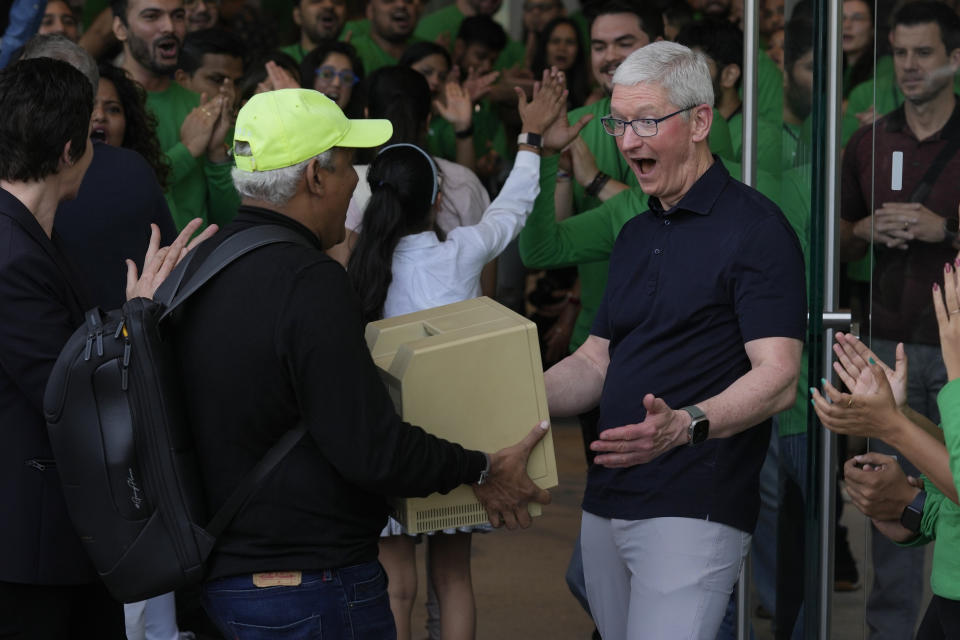 Apple CEO Tim Cook, right, reacts after seeing an old old Macintosh Classic machine brought by a visitor during the opening of the first Apple Inc. flagship store in Mumbai, India, Tuesday, April 18, 2023. Apple Inc. opened its first flagship store in India in a much-anticipated launch Tuesday that highlights the company’s growing aspirations to expand in the country it also hopes to turn into a potential manufacturing hub. (AP Photo/Rafiq Maqbool)