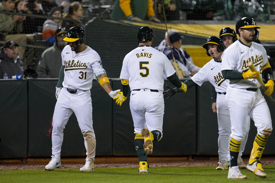 Oakland Athletics' J.D. Davis (5) celebrates with teammates after hitting a solo home run against the Cleveland Guardians during the sixth inning of a baseball game Friday, March 29, 2024, in Oakland, Calif. (AP Photo/Godofredo A. Vásquez)
