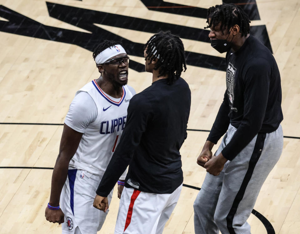 Clippers guard Reggie Jackson (1) celebrates with teammates Terance Mann and Daniel Oturu, right, late in a Game 5 win. (Robert Gauthier/Los Angeles Times via Getty Images)