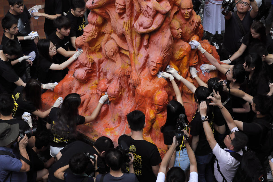 FILE - University students clean the "Pillar of Shame" statue, a memorial for those killed in the 1989 Tiananmen crackdown, at the University of Hong Kong, June 4, 2019. From the military suppression of Beijing’s 1989 pro-democracy protests to the less deadly crushing of Hong Kong’s opposition four decades later, China’s long-ruling Communist Party has demonstrated a determination and ability to stay in power that is seemingly impervious to Western criticism and sanctions. (AP Photo/Kin Cheung, File)