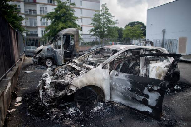 This photograph taken June 29, 2023 in Brest, western of France shows burnt cars at the private parking lot of an organic supermarket partly burnt (AFP via Getty Images)