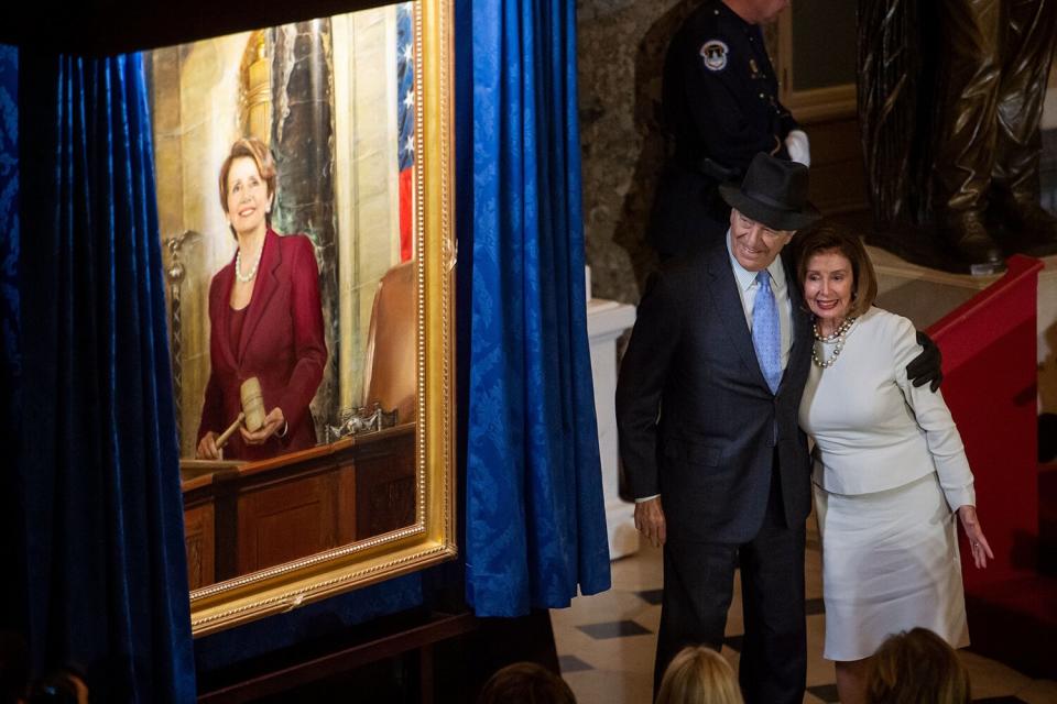 Speaker of the United States House of Representatives Nancy Pelosi (Democrat of California) is embraced by her husband Paul Pelosi during a ceremony to unveil her official portrait in Statuary Hall at the US Capitol in Washington, DC
