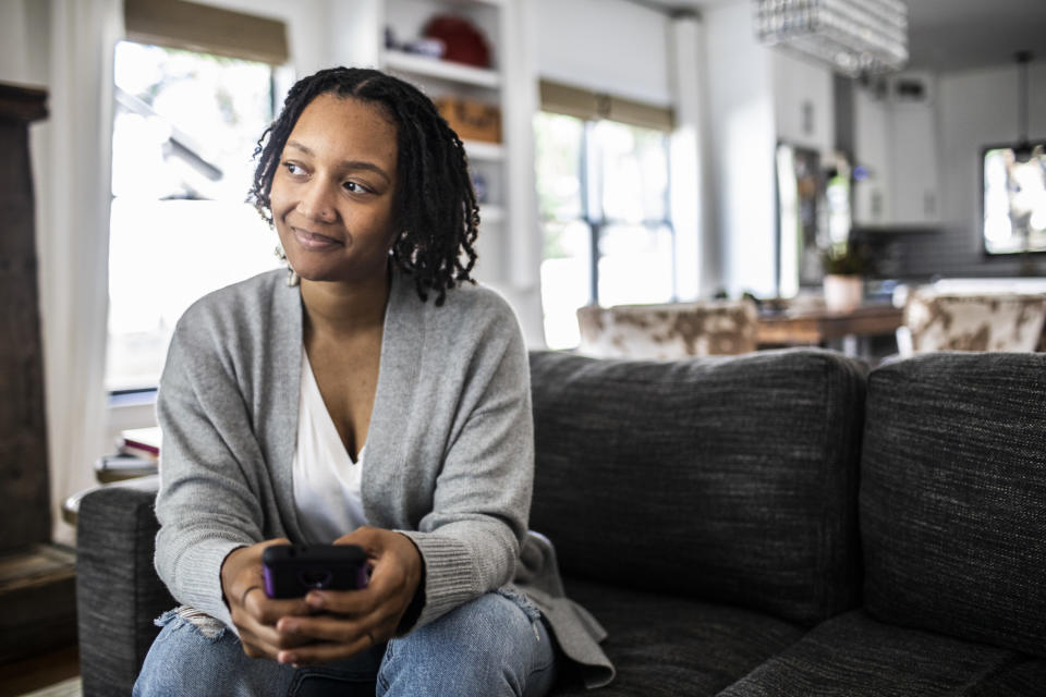 A woman smiling while she's on the couch