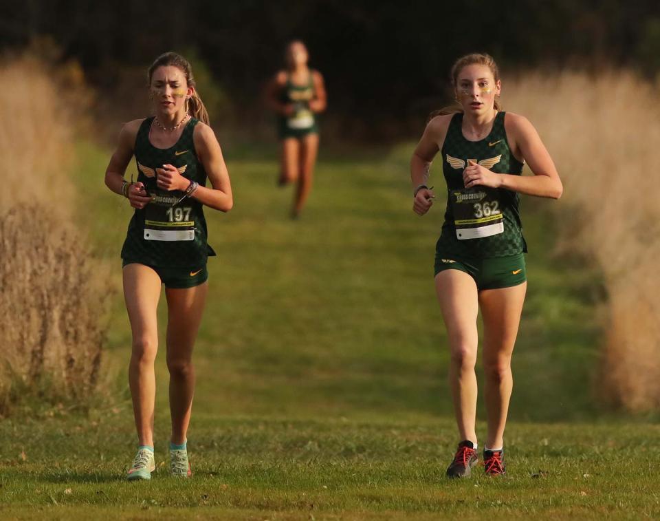 Soraya Ledley, left, and Sarah Schueler, both of Firestone, followed by their teammate Reese Brady, run to a first, second and third place finish in the City Series Cross Country Meet at Goodyear Heights Metro Park Wednesday in Akron. 