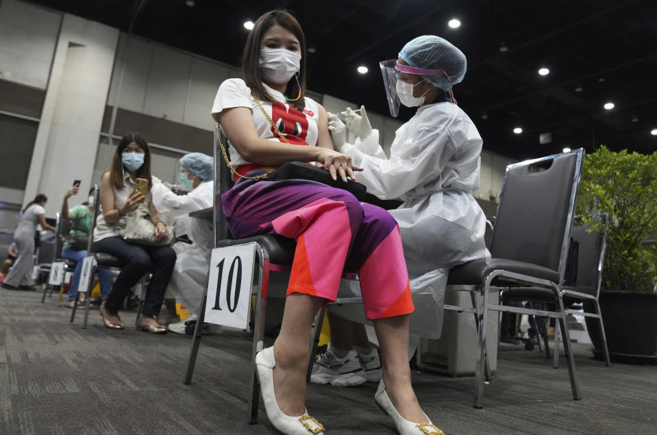 Health workers administer a dose of the AstraZeneca COVID-19 vaccine to women at Paragon shopping mall in Bangkok, Thailand, Monday, June 7, 2021. Health authorities in Thailand on Monday began their much-anticipated mass rollout of locally produced AstraZeneca vaccine, but it appeared that supplies were falling short of demand from patients who had scheduled vaccinations for this week. (AP Photo/Sakchai Lalit)