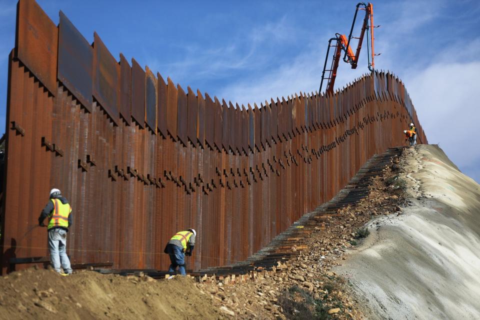 A construction crew works as new sections of the US-Mexico border barrier are installed (Getty Images)