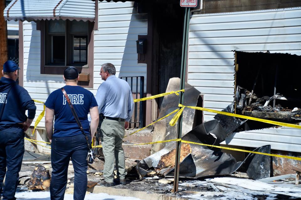 Fire officials, including Hagerstown Fire Marshal Dale Fishack in the blue shirt, check out the building at 24-28 W. Baltimore St., where there was a fire Sunday night.