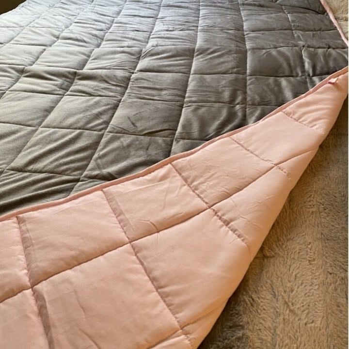 Reviewer's photo of the pink and grey reversible blanket